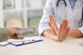 Doctor rejecting bribe in clinic. Corrupted medicine Royalty Free Stock Photo