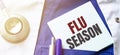 Doctor robe, stethoscope, pens and note with text flu season Royalty Free Stock Photo