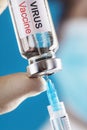 Ampoule with the vaccine against the Virus from diseases on a blue background in the hands of a doctor, scientist in gloves and a