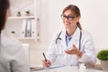 Smiling Doctor Woman Talking With Unrecognizable Patient Sitting In Office Royalty Free Stock Photo