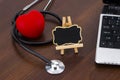 The doctor`s desk with laptop, stethoscope and red heart and bla Royalty Free Stock Photo