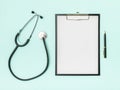 Doctor`s desk top view. Stethoscope and notebook on a colored background