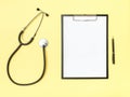 Doctor`s desk top view. Stethoscope and notebook on a colored background