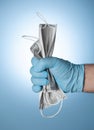 The doctor`s hand in a blue glove clutches medical masks, a symbol of victory over the virus and the epidemic Royalty Free Stock Photo