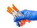 Doctor`s hand in blue medical glove holding several syringes with medical solution white isolated background. Flu Royalty Free Stock Photo