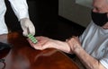 Doctor`s hand gives an old patient a pill. Gerontology service, nursing home. Unrecognizable people, part of the body Royalty Free Stock Photo