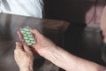 Doctor`s hand gives an old patient a pill. Gerontology service, nursing home. Unrecognizable people, part of the body