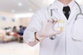 Doctor's hand holding a bottle of urine sample in hospital