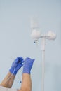 Doctor`s hand and infusion drip in hospital on blurred background