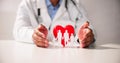 Doctor's Hand Protecting Red Heart With Family Figure Royalty Free Stock Photo