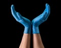 Doctor`s hand in sterile medical gloves hold earth shape on black