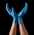 Doctor`s hand in sterile medical gloves hold earth shape isolated on black