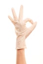 Doctor's hand in white sterilized surgical glove showing OK sign