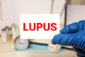 Doctor's hands in blue gloves shows the word lupus. Medical concept Royalty Free Stock Photo