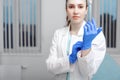 Doctor`s hands putting on latex gloves in a hospital. Woman in a doctor`s smock in latex gloves. Protection against