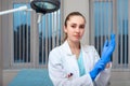 Doctor`s hands putting on latex gloves in a hospital. Woman in a doctor`s smock in latex gloves. Protection against