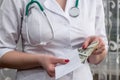 Doctor`s hands putting money into envelope, bribe Royalty Free Stock Photo