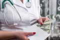 Doctor`s hands putting money into envelope, bribe Royalty Free Stock Photo