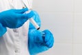 Doctor's hands in rubber medical gloves hold a syringe and an ampoule with medicine in a hospital Royalty Free Stock Photo