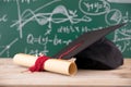 A doctor`s hat in front of a blackboard full of mathematical formulas