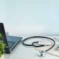 Doctor's office desk with laptop, cardiogram, and stethoscope with copy space