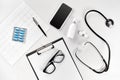 Doctor`s office desk with medical documents, charts, eyeglasses and stethoscope. Top view. Copy space Royalty Free Stock Photo