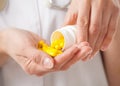Doctor's pouring yellow tablets in the palm Royalty Free Stock Photo