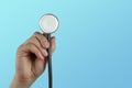 DoctorÃ¢â¬â¢s tool, medical stethoscope in the hands of a doctor against the blau background, concept of national medical care,