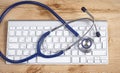 Doctor`s workplace with computer keyboard, stethoscope and glasses Royalty Free Stock Photo