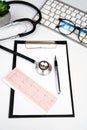 Doctor`s workplace with stethoscope, clipboard and glasses. Close-up. Top view. Selective focus Royalty Free Stock Photo