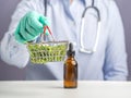 Doctor or Scientist hand holding a basket of marijuana leaves and male buds flowers and cannabis extraction oil bottle