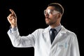 Doctor or scientist in lab coat and safety glasses