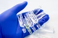Doctor, scientist or pharmacist holds in palm of hand transparent vials or ampules of medicine ready for injection. Concept photo
