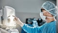 Doctor, scrubs and monitor with machine in theatre for surgery, cardiology analysis and information. Medical, man and Royalty Free Stock Photo