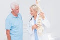 Doctor and senior patient discussing over anatomical spine Royalty Free Stock Photo