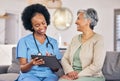 Doctor, senior woman and tablet for consulting, results and happy for good news on sofa in nursing home. Elderly person