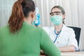 Doctor and senior woman wearing facemasks during coronavirus and flu outbreak. Virus and illness protection, home quarantine.