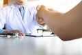 Doctor shakes hands at medical office with patient, wearing glasses, stethoscope and lab coat. Royalty Free Stock Photo