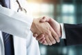 Doctor shaking hands with businessman in healthcare clinic