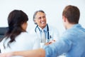 Doctor shaking hands with the patient. Portrait of successful mature doctor shaking hands with young patient in clinic.