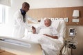 Doctor Shaking Hands With Senior Male Patient In Hospital Bed In Geriatric Unit Royalty Free Stock Photo