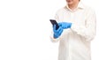Doctor in shirt and blue sterile gloves holds cell phone in hand type text message. Royalty Free Stock Photo