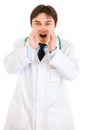 Doctor shouting through megaphone shaped hands Royalty Free Stock Photo