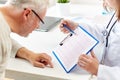 Doctor showing cardiogram to old man at hospital Royalty Free Stock Photo