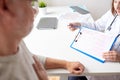 Doctor showing cardiogram to old man at hospital Royalty Free Stock Photo