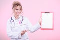 Doctor showing folder with pink ribbon by pen. Royalty Free Stock Photo