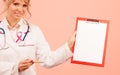 Doctor showing folder with pink ribbon by pen. Royalty Free Stock Photo