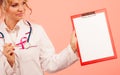Doctor showing folder with pink ribbon by pen. Royalty Free Stock Photo
