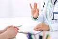 Doctor showing Ok sign with thumb up to patient while sitting at the desk in hospital office, close-up of human hands