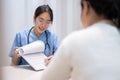 A doctor showing reports and giving advice to a patient during a medical check-up at the hospital Royalty Free Stock Photo